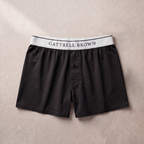 Black boxer shorts with a white waistband featuring 'Gattrell Brown' on a beige background