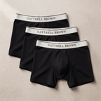 Three black boxer briefs with white waistbands labeled 'Gattrell Brown' on a beige background.