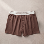 Brown boxer shorts with a white waistband featuring 'Gattrell Brown' on a beige background