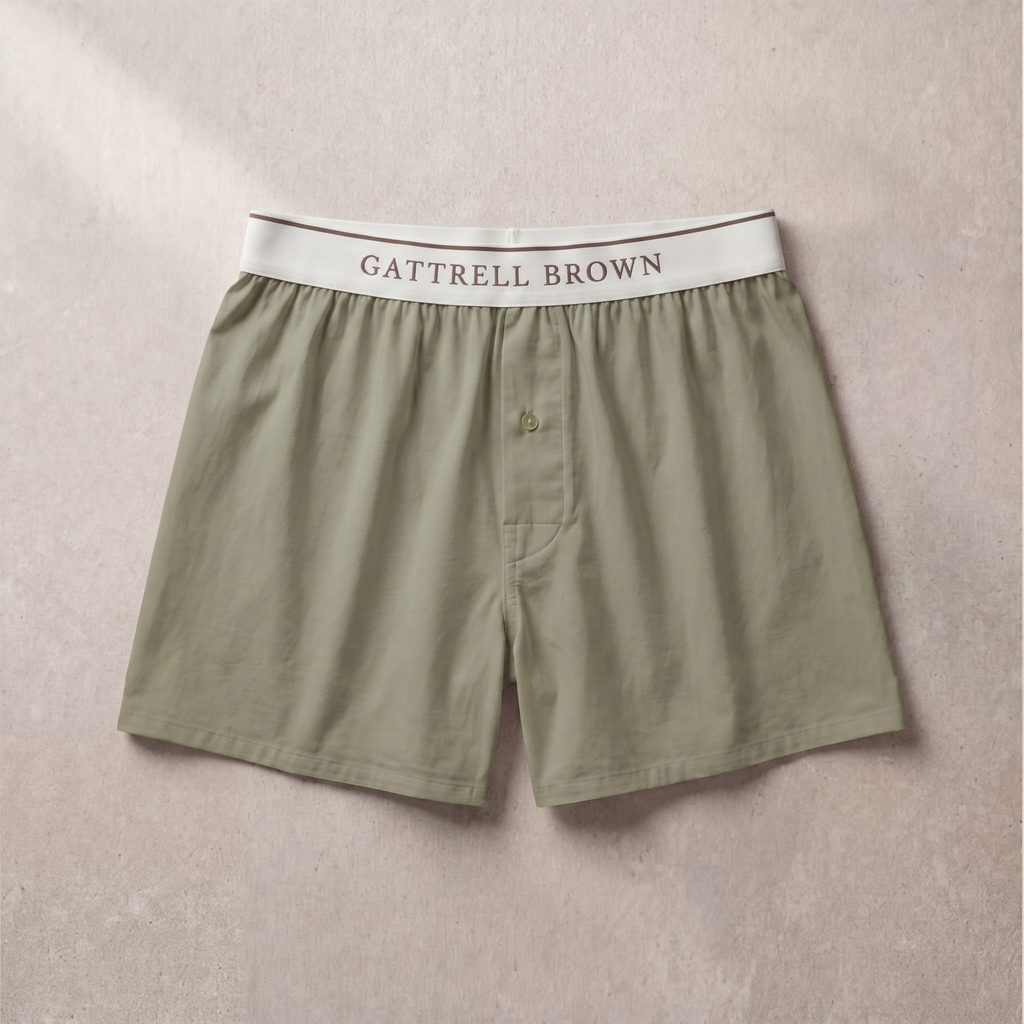 Green boxer shorts with a white waistband on a beige background