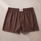 Brown striped boxer shorts with a visible brand label on a beige background